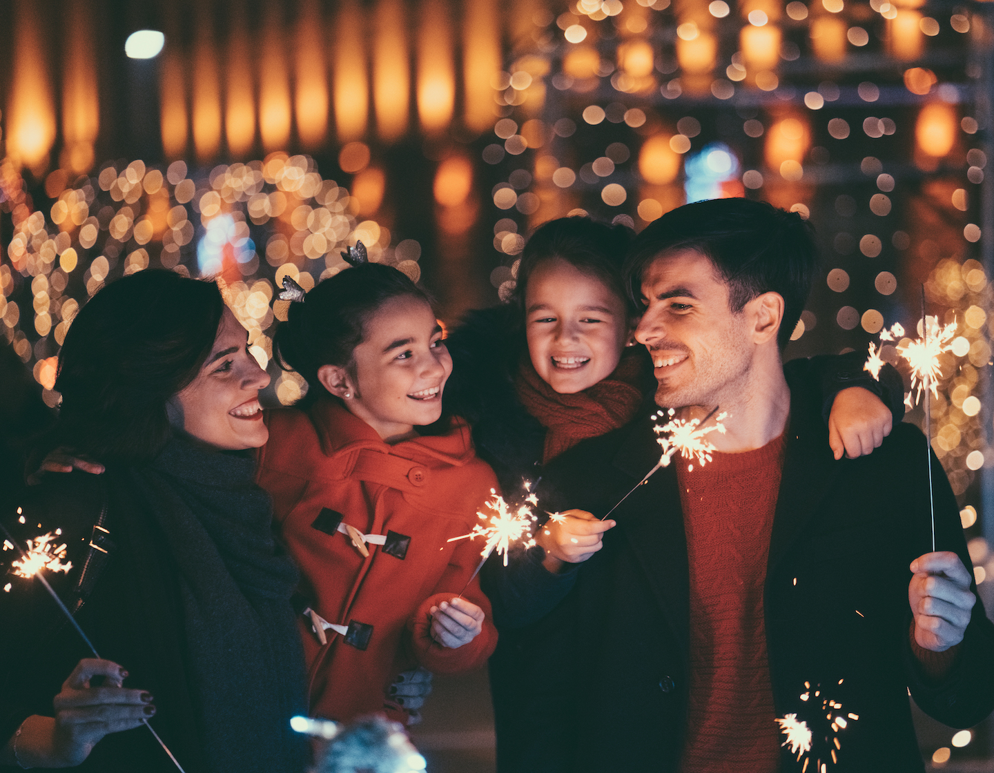 Happy family on Christmas with burning sparklers