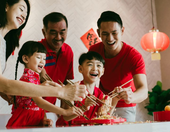 Family tossing of Yee Sang, traditional Chinese New Year prosperity delicacies.